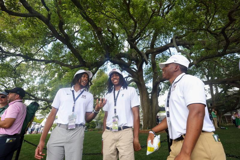 Morehouse College men’s golf team members Senai Griffin, left, his brother Sevan Griffin, and James Pierson talk under the oak tree next to the clubhouse during the practice round of the 2024 Masters Tournament at Augusta National Golf Club, Wednesday, April 10, 2024, in Augusta, Ga. (Jason Getz / jason.getz@ajc.com)