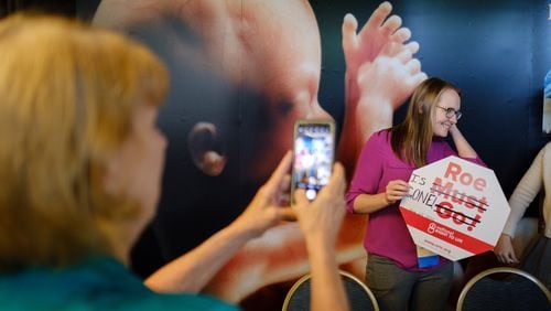 A volunteer with National Right to Life holds a sign that has been adjusted to say “Roe is Gone” at the National Right to Life Convention at the Airport Marriott Hotel in Atlanta on Friday, June 24, 2022, the day the U.S. Supreme Court overturned Roe v. Wade. (Arvin Temkar / arvin.temkar@ajc.com)