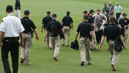 April 3, 2017, Augusta: GBI officers join security guards along the first fairway to help clear patrons from the golf course during a tornado watch suspending practice for the Masters at Augusta National Golf Club on Monday, April 3, 2017, in Augusta.   Curtis Compton/ccompton@ajc.com