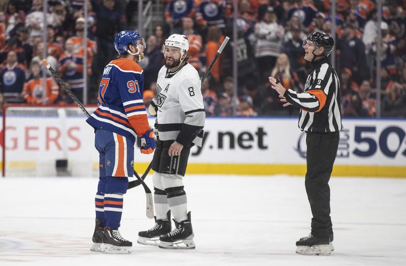 Los Angeles Kings' Drew Doughty (8) laughs as Edmonton Oilers' Connor McDavid (97) argues with an official about a no-goal call during the first period of Game 2 of an NHL hockey Stanley Cup first-round playoff series Wednesday, April 24, 2024, in Edmonton, Alberta. (Jason Franson/The Canadian Press via AP)