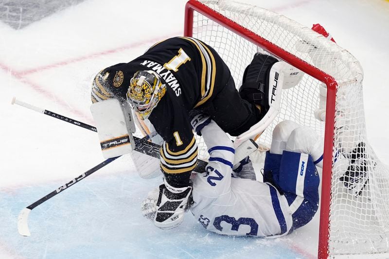 Toronto Maple Leafs' Matthew Knies (23) collides with Boston Bruins' Jeremy Swayman (1) during the second period of Game 7 of an NHL hockey Stanley Cup first-round playoff series, Saturday, May 4, 2024, in Boston. (AP Photo/Michael Dwyer)