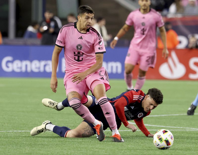 New England Revolution forward Tomás Chancalay, bottom right, falls while chasing the ball behind Inter Miami midfielder Tomás Aviles, front left, in the first half of an MLS soccer match Saturday, April 27, 2024, in Foxborough, Mass. (AP Photo/Mark Stockwell)