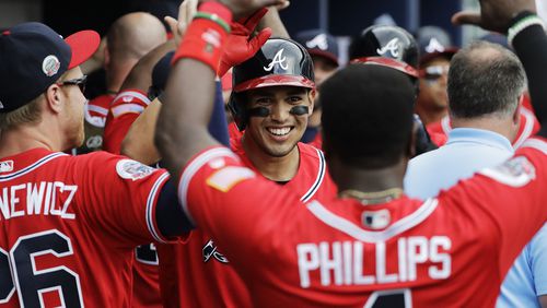 Atlanta Braves&#039; Rio Ruiz, center, high-fives Brandon Phillips after Ruiz hit a two-run home run to score Dansby Swanson in the second inning of a baseball game against the Washington Nationals in Atlanta, Saturday, May 20, 2017. (AP Photo/David Goldman)