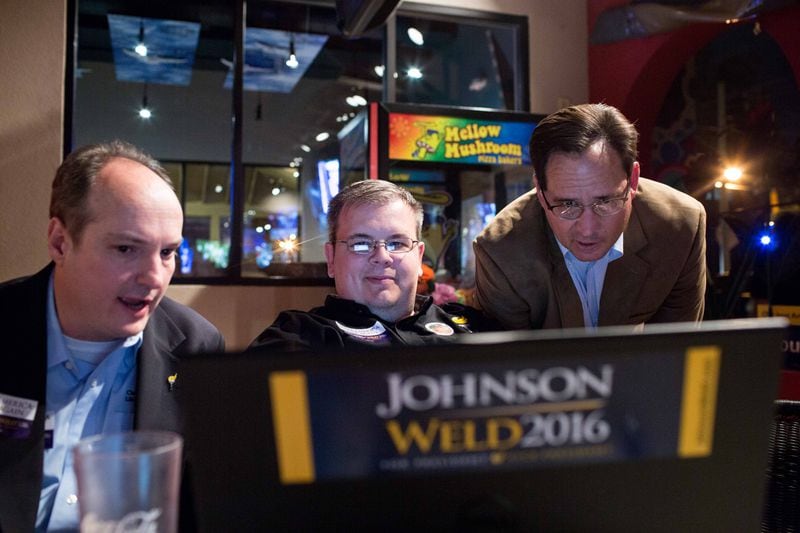 Brett Larson, from left, Nathan Wilson, executive director of the Libertarian Party of Georgia, and Libertarian U.S. Senate candidate Allen Buckley watch election results on a computer during a Libertarian watch party in November 2016 at the Mellow Mushroom in Atlanta. (BRANDEN CAMP/SPECIAL)