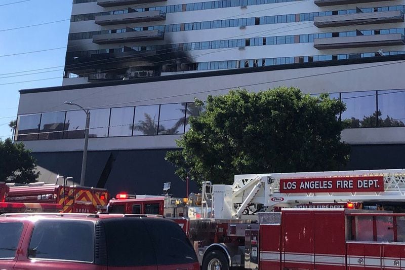 Firefighters respond to a fire at a residential building in Los Angeles, Wednesday, Jan. 29, 2020. Firefighters swarmed the building on the city's west side and people could be seen on the roof as flames and smoke rise from the sixth floor. A helicopter was hoisting people off the roof.
