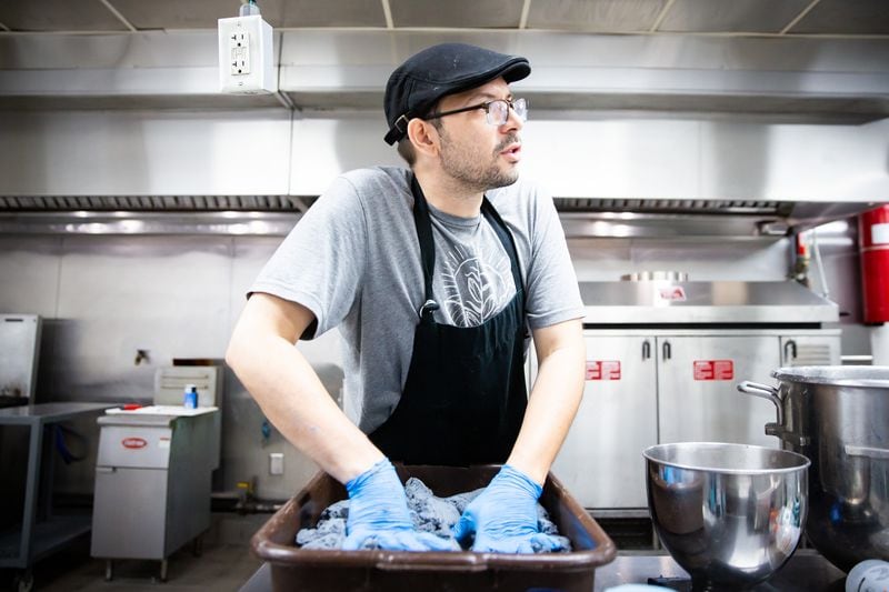 Aaron Harris massages freshly prepared blue corn masa prior to feeding it into an automated machine that shapes and cooks the tortillas. Ryan Fleisher for The Atlanta Journal-Constitution 