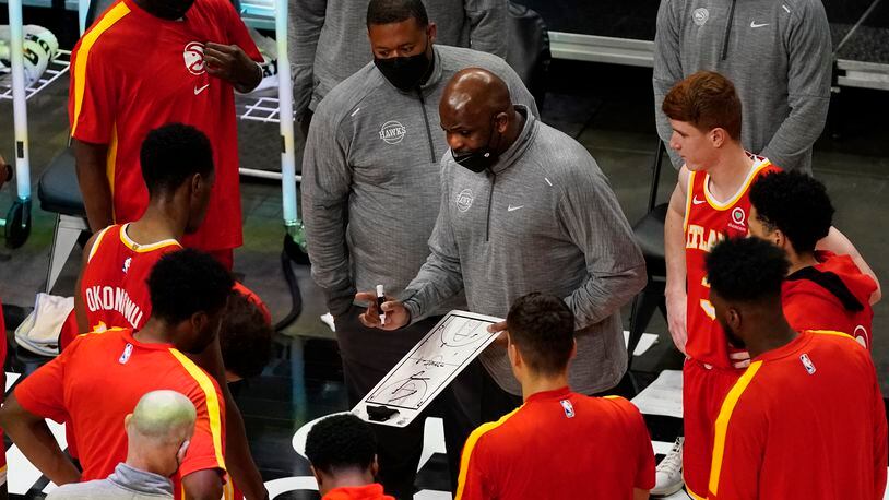 Atlanta Hawks head coach Nate McMillan, center, draws a play before the start of the second half of an NBA basketball game after the game Wednesday, April 7, 2021, in Atlanta. (AP Photo/John Bazemore)