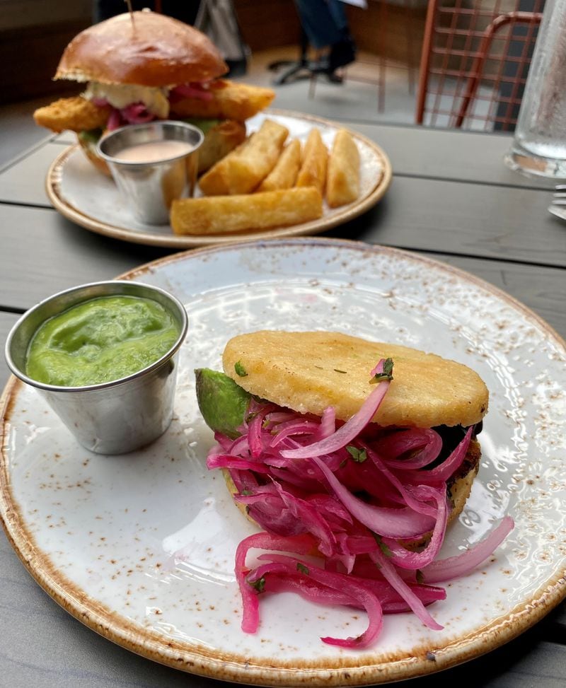 At El Vinedo Local, Uruguayan-born executive chef Bruno Vergara makes South American dishes like this arepa vegetales (front) and pan con pescado (fried fish sandwich, rear). 
Wendell Brock for The Atlanta Journal-Constitution