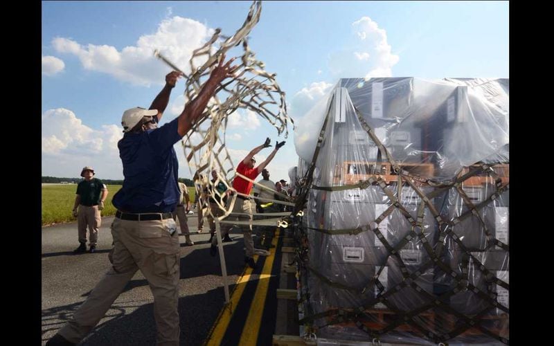A Department of Health and Human Services employee throws a cargo net over a pallet at Dobbins Air Reserve Base on Sept. 21, 2017. This cargo included items needed to build a hospital from scratch — everything from the tents required to house the temporary structure to the medical equipment used to treat patients.