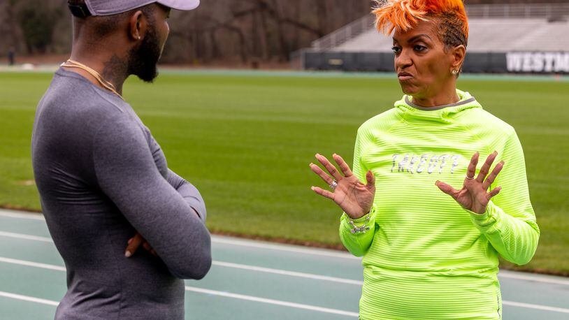 Sprinter India Bridgette (right) talks with her coach, Dantwan Spreads of TakeOff Track Club, as she practices at the Westminster Schools track. The Marietta resident is setting records as a senior runner. PHIL SKINNER FOR THE ATLANTA JOURNAL-CONSTITUTION