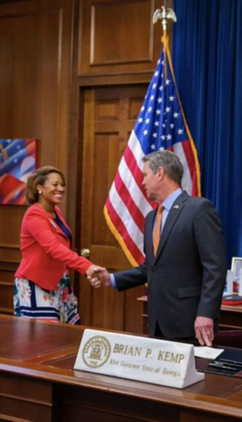 State. Rep. Mesha Mainor, a Democrat from Atlanta, shakes Republican Gov. Brian Kemp's hand as he signed a bill she backed allowing the formation of a unified police force at the Atlanta University Center.