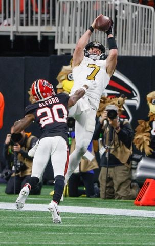 New Orleans Saints Taysom Hill (7) completes a pass in front of Atlanta Falcons cornerback Dee Alford (20) during the first half of na NFL football game in Atlanta on Sunday, Nov. 26, 2023.   (Bob Andres for the Atlanta Journal Constitution)