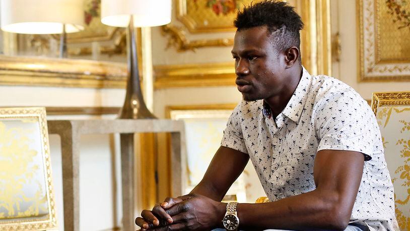 Mamoudou Gassama, 22, from Mali, is pictured during a meeting with French President Emmanuel Macron at the presidential Elysee Palace in Paris, Monday, May, 28, 2018. Mamoudou Gassama living illegally in France is being honored by Macron for scaling an apartment building over the weekend to save a 4-year-old child dangling from a fifth-floor balcony. (AP Photo/Thibault Camus, Pool)