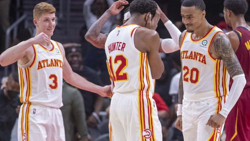 Hawks forward John Collins (20) and his teammates react after a Collins dunk during a preseason game at State Farm Arena.