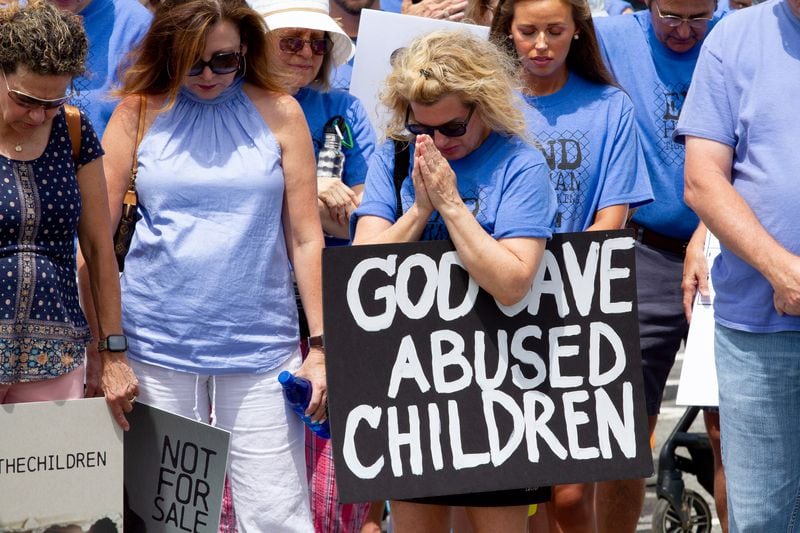 Standing with the Children protesters take a moment to pray at Woodstock Elementary before heading to the Elm Street Event Green in Woodstock Saturday, August 22, 2020.  STEVE SCHAEFER FOR THE ATLANTA JOURNAL-CONSTITUTION