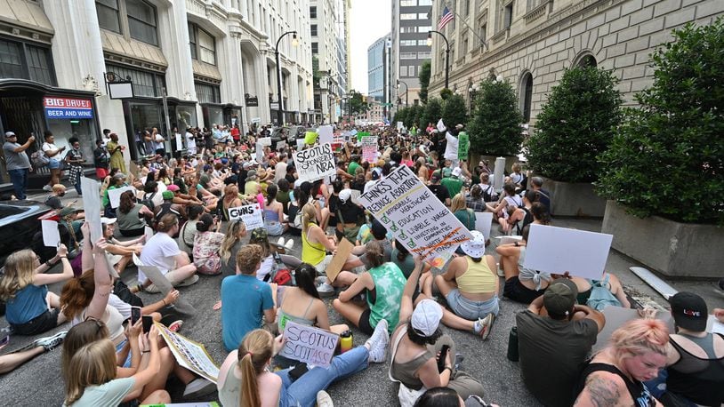 People "play dead" outside the U.S. Court of Appeals building as they protest the Supreme Court's decision to overturn Roe v. Wade in downtown Atlanta on Saturday, June 25, 2022. Some expect confusion and conflict on college campuses when students return for the fall semester. (Hyosub Shin / Hyosub.Shin@ajc.com)