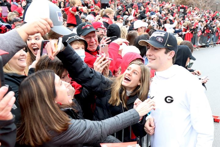 A Georgia Bulldog fan takes a selfie with quarterback Stetson Bennet as the team arrive at the dog-walk during the victory parade in downtown Athens onSaturday, January 15, 2022 Miguel Martinez for The Atlanta Journal-Constitution