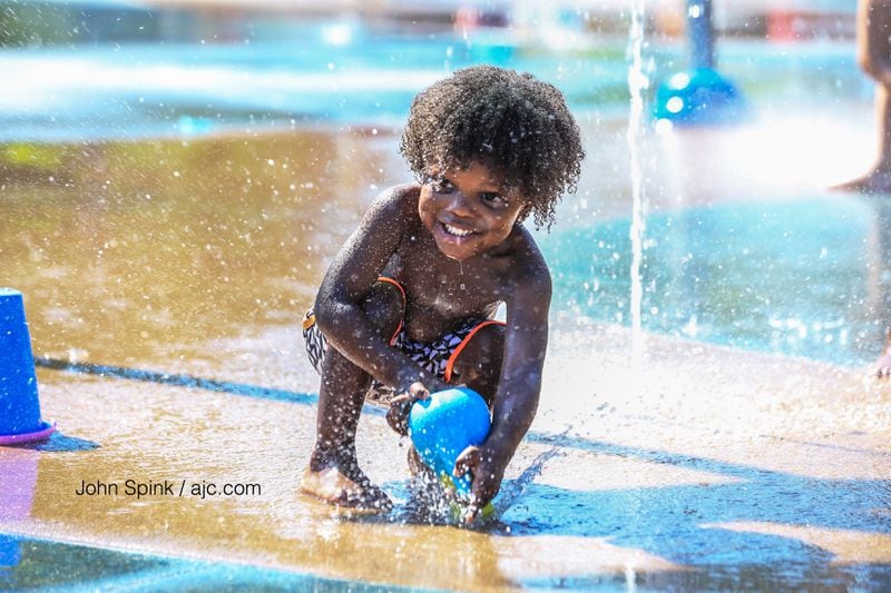 With Monday expected to feel like a 'steam bath,' 2-year-old Tre Toole decided to cool off in the Historic Old Fourth Ward Splash Pad. JOHN SPINK / JSPINK@AJC.COM