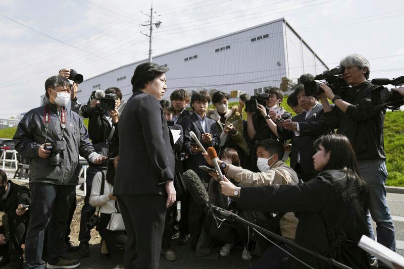 An employee of Kobayashi Pharmaceutical Co. speaks to media members outside a plant operated by its subsidiary after Japan's health ministry officials walked into the plant to conduct an on-site inspection in Kinokawa, south of Osaka, western Japan, Sunday, March 31, 2024. Japanese government health officials on Sunday inspected the factory producing health supplements linked to several deaths and the hospitalization of more than 100 others, one day after the authorities investigated another plant that manufactured the product. (Yohei Fukai/Kyodo News via AP)