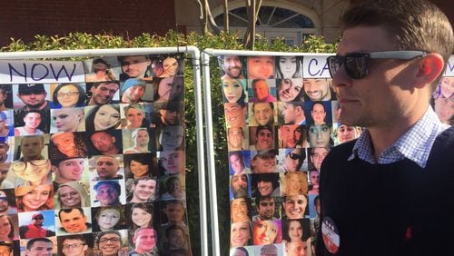 Brett Bramble stands in front of a photo montage of people who died from addiction, including his sister, Brittany. The banner was on display at a recent event across from the Georgia Capitol, to raise awareness for addiction recovery. Bramble sees the state Department of Behavioral Health and Developmental Disabilities as key to stopping the toll of addiction and mental health crises. (PHOTO by Ariel Hart / ahart@ajc.com)