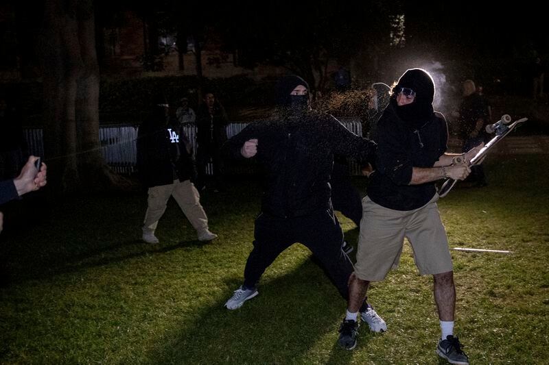 Demonstrators clash at a pro-Palestinian encampment at UCLA late Tuesday, April 30, 2024, in Los Angeles. Dueling groups of protesters have clashed at the University of California, Los Angeles, grappling in fistfights and shoving, kicking and using sticks to beat one another. (AP Photo/Ethan Swope)