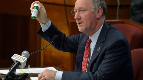 Georgia State Rep. Allen Peake, R-Macon shows a bottle of medical cannabis oil as he presents his House Bill 1 on Feb. 3, 2015. BRANT SANDERLIN / BSANDERLIN@AJC.COM