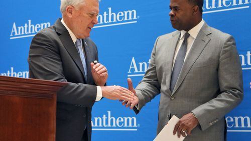 In this 2016 photo, Gov. Nathan Deal and former Atlanta Mayor Kasim Reed stand in front of a wall printed with the name of Anthem, the parent company of Blue Cross Blue Shield of Georgia. This week, Deal has announced that for the first 30 days the state will pay the extra out-of-network costs for state employees who have a state Blue Cross insurance plan and see Piedmont healthcare providers. The move could cost the state about $42 million. The state university system has done the same. PHOTO by BOB ANDRES /BANDRES@AJC.COM