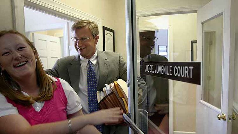 In this 2007 file photo, then Judge Tom Rawlings, led by Jessica Whitehead, a probation officer with the Department of Juvenile Justice, heads out of his Sandersville office after holding juvenile court on June 27, 2007. It was Rawlings' last court appearance in Sandersville before moving to his new position as the state's child advocate.