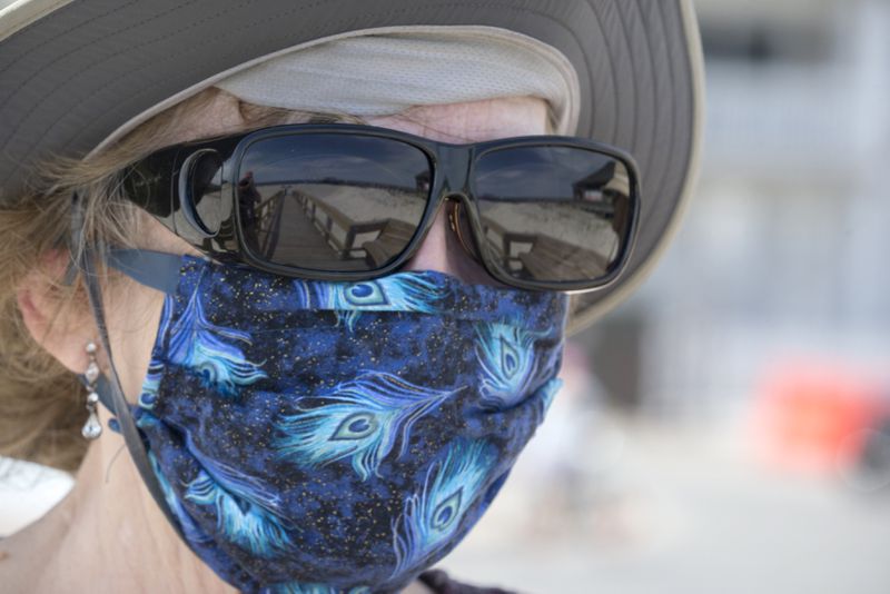 A local visitor walks along a dune crossover to Tybee Island beach with her handmade face mask on Saturday, April 4, 2020,  a day after Gov. Brian Kemp signed an executive order allowing people to exercise outside, with social distancing of at least 6 feet. (Photo: Stephen B. Morton/Special to the AJC)
