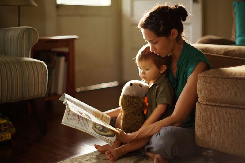 Cynthia King reads to her son Dexter Muir at their home in Honolulu, Hawaii, in 2016. (Courtesy of Cory Lum/Civil Beat)