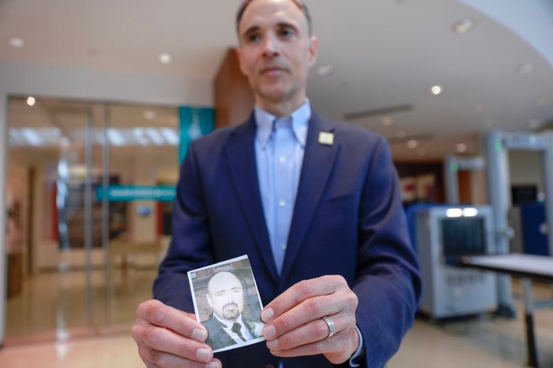 Anthony Gardner, Public Affairs Specialist at the World Trade Center Health Program holds a photo of his brother Harvey Joseph Gardner III, who died on September 11 at “The Health Effects of 9/11” exhibit at the CDC Museum on Thursday, September 7, 2023. (Natrice Miller/ Natrice.miller@ajc.com)