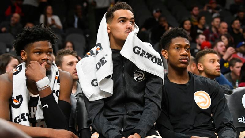 Atlanta Hawks forward Cam Reddish (from left), guard Trae Young and forward De'Andre Hunter watch the final moments of the game against the Detroit Pistons from the bench, Saturday, Jan. 18, 2020, in Atlanta. (John Amis/AP)