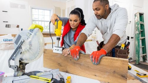 As seen on HGTV's Married to Real Estate, hosts Egypt Sherrod (L) and Mike Jackson (R) work together to prepare and hang floating shelves in the Henderson's kitchen. (Working)