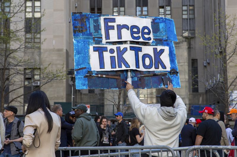 A man carries a TikTok sign in front of the courthouse where the hush-money trial of Donald Trump got underway last week. The House has passed legislation Saturday to ban TikTok in the U.S.