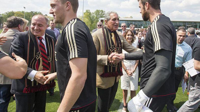 Atlanta United President Darren Eales, left, and Owner and Chairman Arthur Blank get congratulatory handshakes and thanks from star players Julian Gressel and goalie Alec Kann on Tuesday, April 11, 2017, at the team's new training facility in Marietta, Ga.