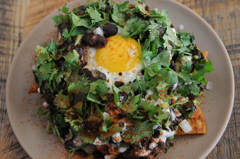 Hungry diners can fill up on chilaquiles, a dish of fried tortilla wedges smothered with beans and pork, crema, salsa, queso fresco, avocado and a fried egg at Minero in Ponce City Market. (Becky Stein Photography)