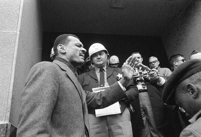 C.T. Vivian, integration leader, left, leads a prayer on the courthouse steps in Selma, Ala., February 5, 1965, after Sheriff James Clark, background with helmet, stopped him at the door with a court order. Vivian led hundreds of demonstrators armed with petitions asking longer voter registration hours. Clark arrested them when they refused to disperse. (AP Photo/Horace Cort)