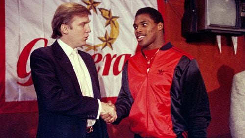 Donald Trump shakes hands with Herschel Walker in New York in March 1984 after agreement on a 4-year contract with the New Jersey Generals USFL football team. (AP Photo/Dave Pickoff, File)