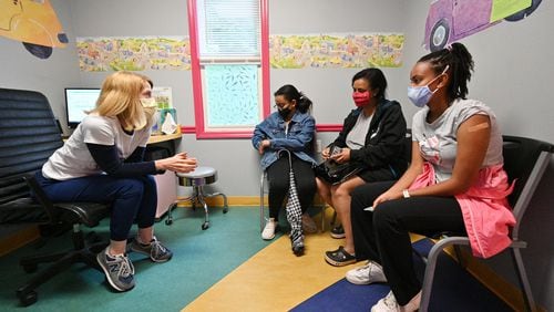 Dr. Debby Pollack (left) talks to Miriam Araya (right), 15, and her mother Betty Kidanu and sister Melina  Araya, 11, after Miriam received a first dose of the Pfizer-BioNTech vaccine at Dekalb Pediatric Center. (Hyosub Shin / Hyosub.Shin@ajc.com)