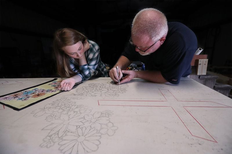 While daughter Lauren Clamp watches, Mart Clamp uses a precision knife to cut a stencil for the memorial he is making for his father, who, like his father before him, worked in the granite industry in Elberton. Curtis Compton/ccompton@ajc.com