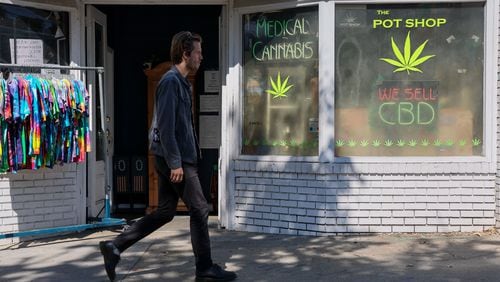 A person walks past The Pot Shop in Atlanta. In a new Atlanta Journal-Constitution poll, about 53% of Georgia registered voters supported legalizing recreational use of marijuana. (Arvin Temkar / arvin.temkar@ajc.com)