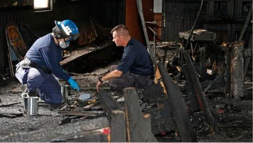 A state fire marshal (right) and an ATF agent collect evidence as they investigate the fire-damaged Hopewell Missionary Baptist Church in Greenville, Miss., Nov. 2. Fire Chief Ruben Brown Sr. said firefighters found flames and smoke pouring from the sanctuary of the church after 9 p.m. Nov. 1. AP PHOTO / ROGELIO V. SOLIS