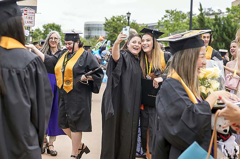 05/09/2019  -- Kennesaw, Georgia -- Kennesaw State University Prof. Amanda Wansa Morgan (center) takes a selfie with KSU alumnus Shannon Murphy (right) following the 223rd Kennesaw State University commencement ceremony at the convocation center on the university's main campus in Kennesaw, Thursday, May 9, 2019. (ALYSSA POINTER/ALYSSA.POINTER@AJC.COM)