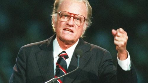 In this Oct 26, 1994 file photo, Evangelist Billy Graham begins his sermon in Atlanta's Georgia Dome. Graham, who transformed American religious life through his preaching and activism, becoming a counselor to presidents and the most widely heard Christian evangelist in history, has died. Spokesman Mark DeMoss says Graham, who long suffered from cancer, pneumonia and other ailments, died at his home in North Carolina on Wednesday, Feb. 21, 2018. He was 99. AP Photo/John Bazemore, File