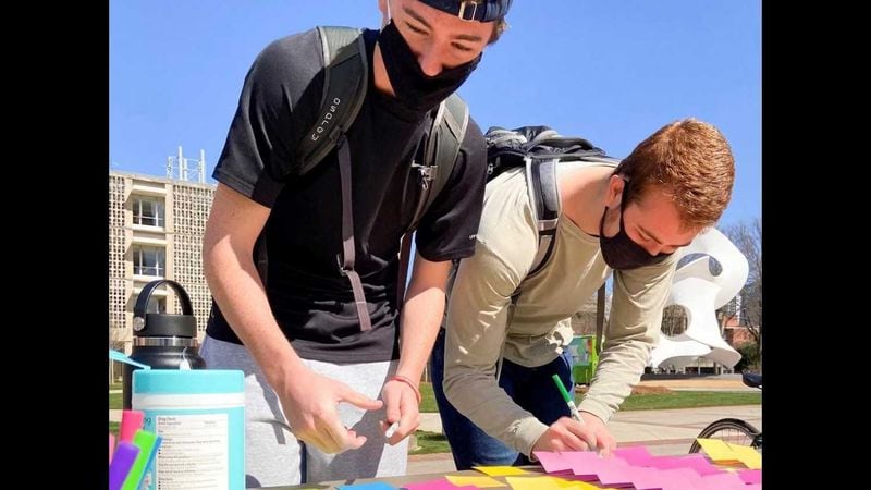Two Georgia Tech students sign notes discussing their feelings during a wellness event on its main campus. PHOTO CONTRIBUTED.