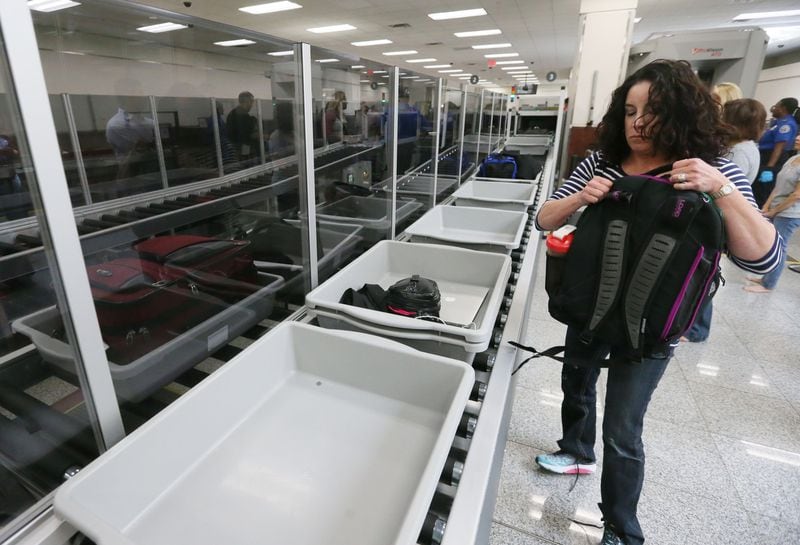 May 25, 2016 - Atlanta - Ami Ewald, from Ohio,, picks up bags after going through the new process. She said she didn't think it was an improvement. TSA unveiled new security "smart lanes" that have been installed in the South Security Checkpoint, which feature automated equipment that handles baggage. BOB ANDRES / BANDRES@AJC.COM