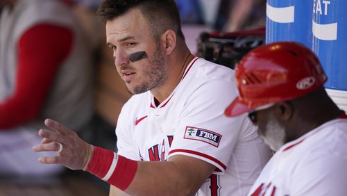 Los Angeles Angels designated hitter Mike Trout, left, speaks with third base coach Eric Young Sr. during the fifth inning of a baseball game against the Minnesota Twins, Sunday, April 28, 2024, in Anaheim, Calif. (AP Photo/Ryan Sun)