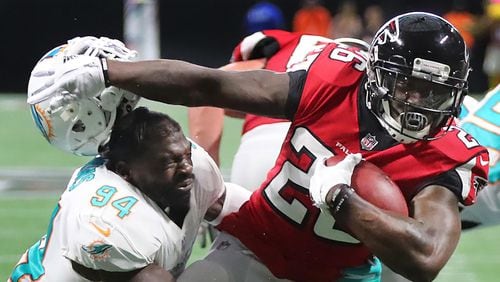 October 15, 2017 Atlanta: Falcons running back Tevin Coleman seperates Miami linebacker Lawrence Timmons from his helmet as he breaks the tackle to run for a touchdown taking a 17-0 lead during the second half in a NFL football game on Sunday, October 15, 2017, in Atlanta.   Curtis Compton/ccompton@ajc.com