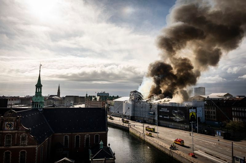Firefighters work at the scene as smoke rises from the Stock Exchange in Copenhagen, Denmark, Tuesday, April 16, 2024. A fire raged through one of Copenhagen’s oldest buildings on Tuesday, causing the collapse of the iconic spire of the 17th-century Old Stock Exchange as passersby rushed to help emergency services save priceless paintings and other valuables. (Emil Nicolai Helms/Ritzau Scanpix via AP)