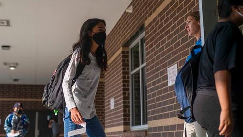 Physical Education Coach Monica Sicka greets a few masked students as they enter Pearson Middle School during the first day of school in Marietta, Monday, August 2, 2021. (Alyssa Pointer/Atlanta Journal Constitution)